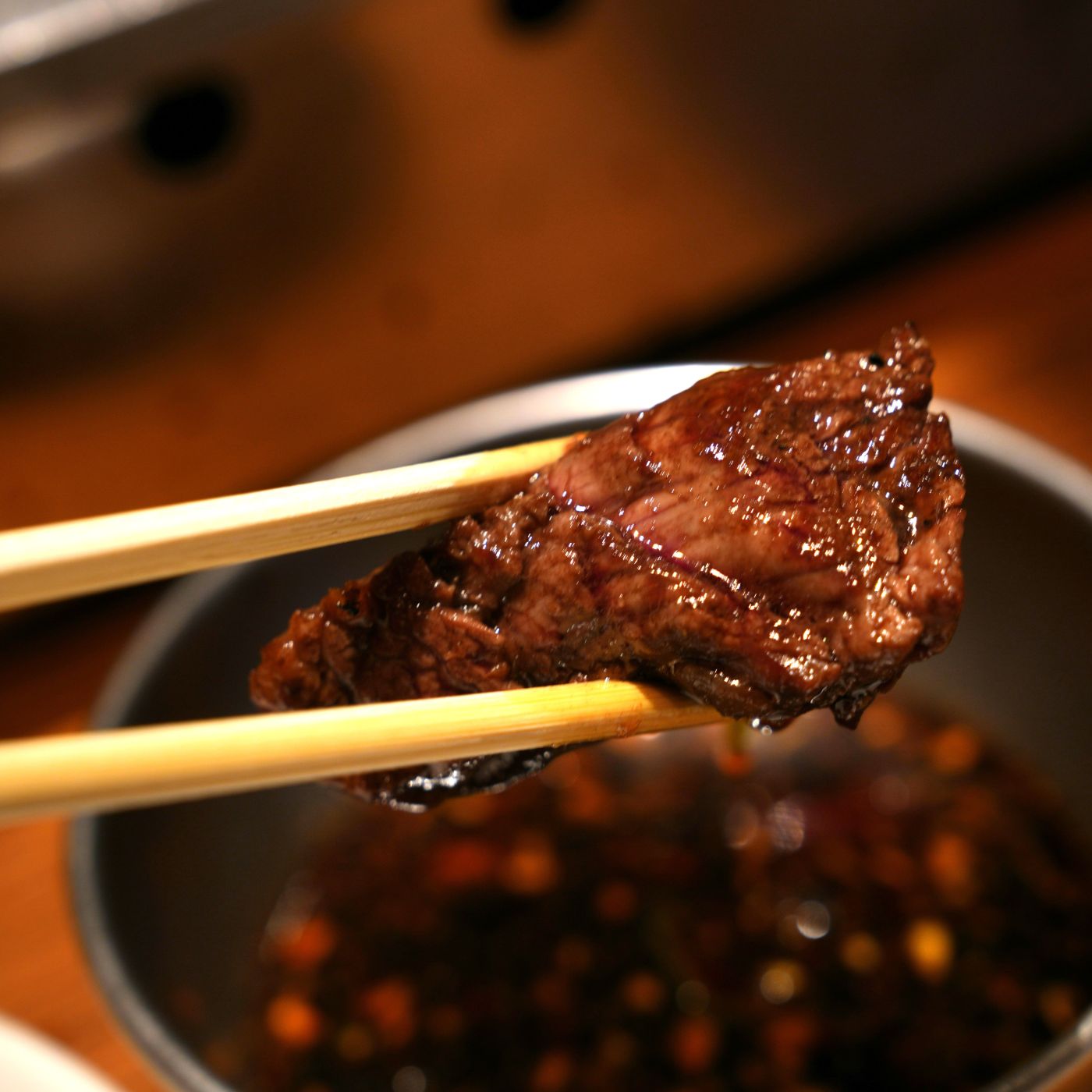 甘辛いたれの焼肉を箸で持ち上げている