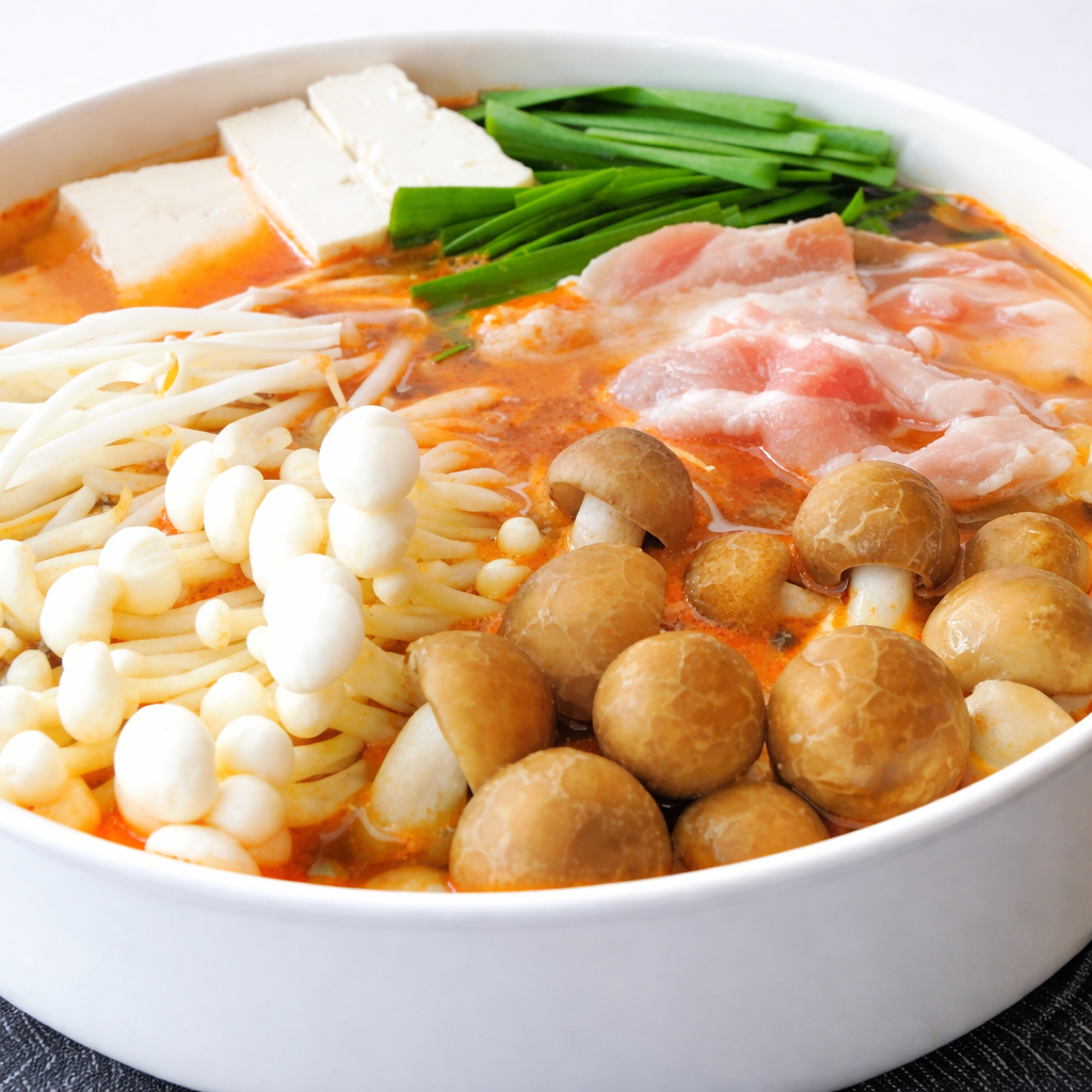 お鍋の中にお肉と野菜(にら、えのき、しめじ)とお豆腐が入ったキムチ鍋