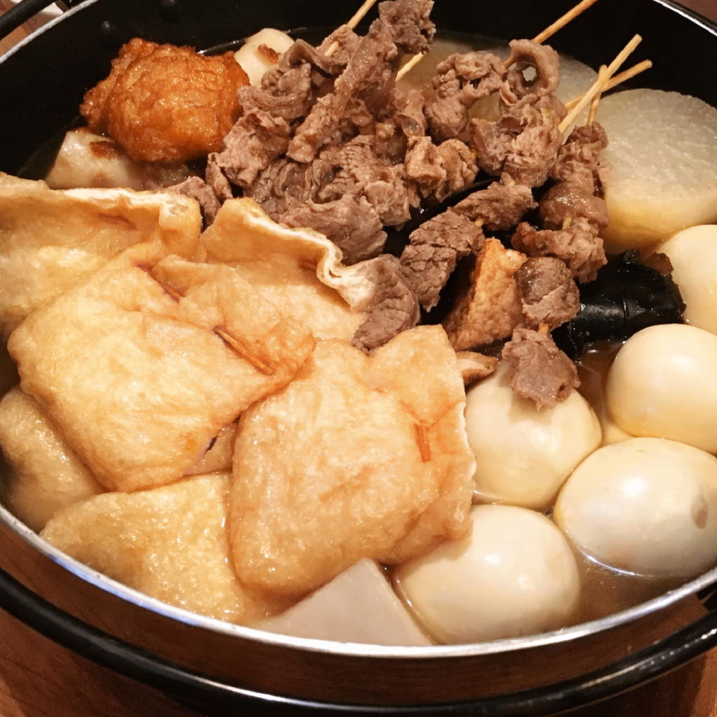 お鍋の中に牛すじと卵、もち巾着、大根、昆布、ちくわが入ったおでん