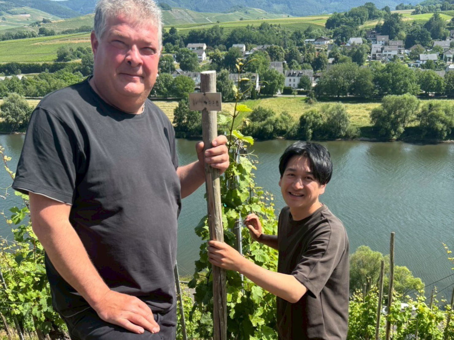 ドイツの川とブドウ農園を背景に男性2人がいる